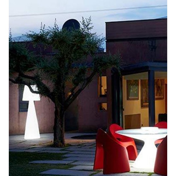 Lampada da terra Pivot accesa in terrazza esterna di notte vicino a un albero