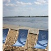 Custom beach chair with monogram logo arranged in row at water's edge