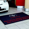 Mata personalizowana niebieska logo Toyota zainstalowana na podłodze salonu samochodowego
