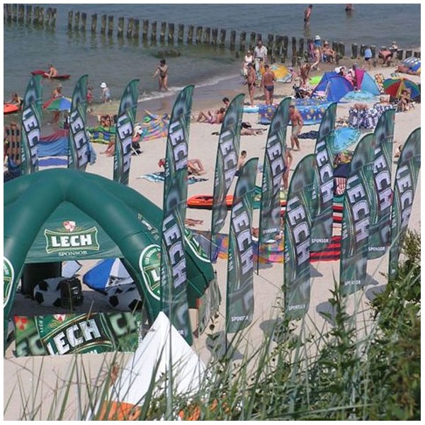 Zöld kerek reklám zászlók Lech felirattal strand mellett felfújható sátor mellett