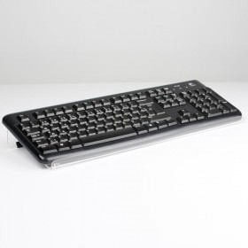 Transparent ergonomic keyboard support placed under black keyboard, angled view