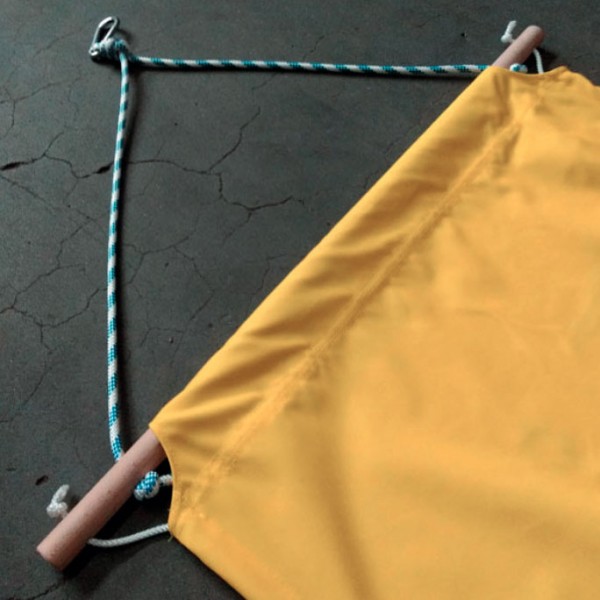 Custom yellow hammock fastening with cord and wooden bar at ends