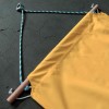 Custom yellow hammock fastening with cord and wooden bar at ends