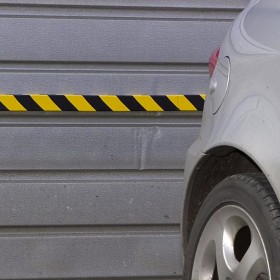 Schiuma protezione murale antiurto gialla e nera fissata su muro garage