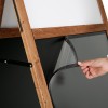 Houten ezel met een elegant ontwerp, geplaatst voor een winkel met een speciale aanbieding.