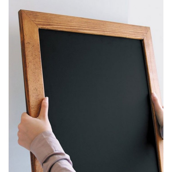 Pizarra con marco de madera sostenida en mano, esquina superior del panel negro