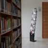 Espositore per brochure da terra 4 × A4 nero con brochure in uno spazio di accoglienza
