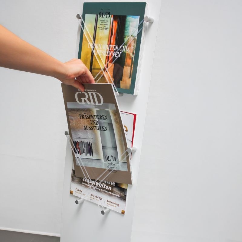 Taking an A4 brochure out of the Velo Restyle brochure holder filled with magazines.