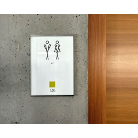 Moldura Glassnox Wall em sinalética de porta de WC, numa parede de betão