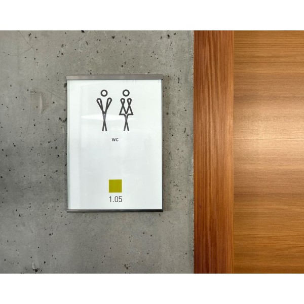 Ramka Glassnox Wall jako oznakowanie drzwi WC na betonowej ścianie